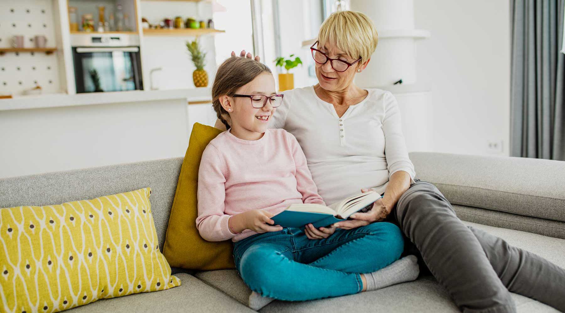 Grandmother and child reading on the couch.